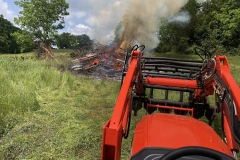 Feeding and tending a barn demo burn pile.